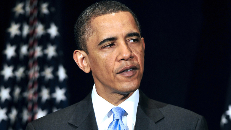 U.S. President Barack Obama wears a blue tie and gives a speech in front of a U.S. flag