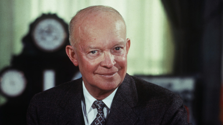 U.S. President Dwight D. Eisenhower smiles for a picture at his desk