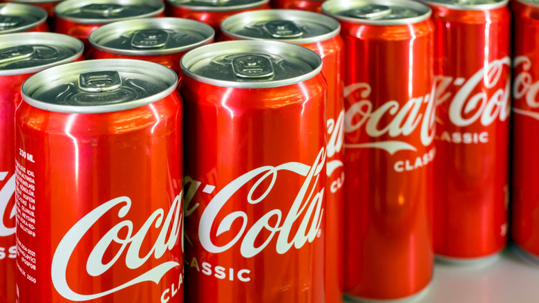 Cans of Coca-Cola standing in neat rows
