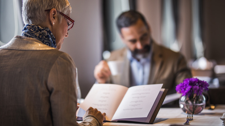 couple reading restaurant menus