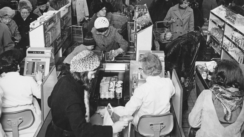 Cashiers checking customers out in 1970s