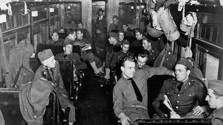 Numerous soldiers in uniform riding a train during World War II