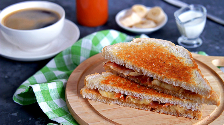 Peanut butter, banana and bacon sandwich triangles on a wooden board