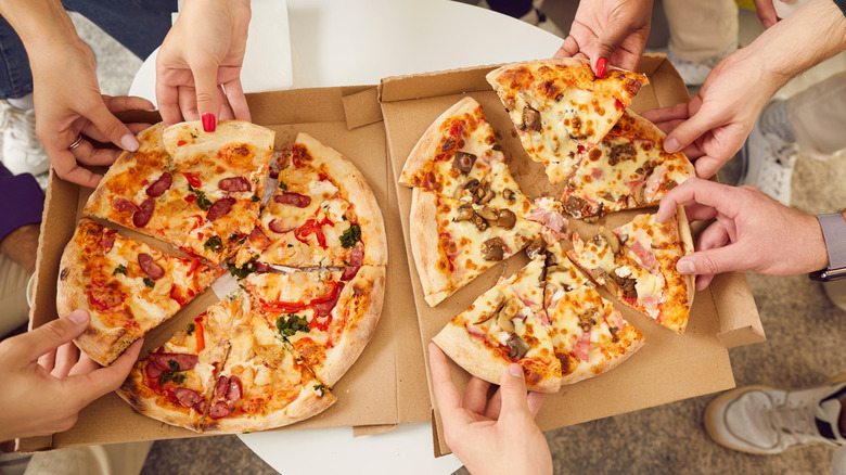 friends splitting takeout pizza