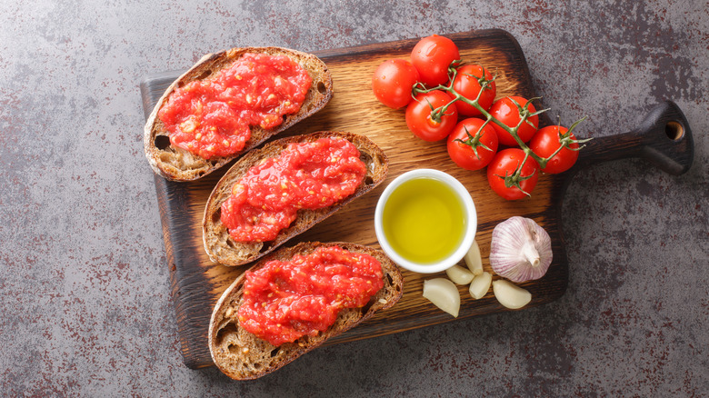 Pan con tomate slices alongside tomatoes, oil, and garlic