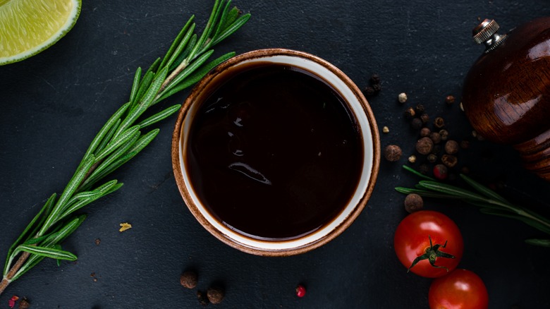 soy sauce in a bowl with herbs, spices, and tomatoes