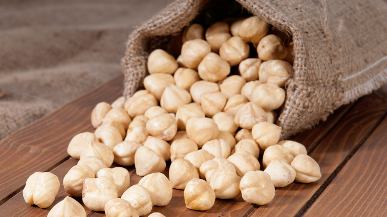 Bag of hazelnuts rolling onto table