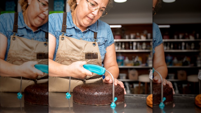A baker cutting a cake with a cake leveler
