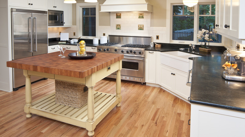 A small cook's table sits in the center of a kitchen