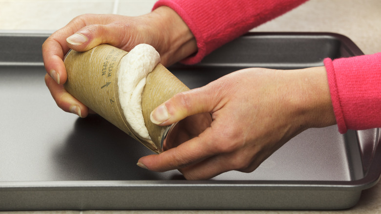 person opening canned refrigerated biscuits