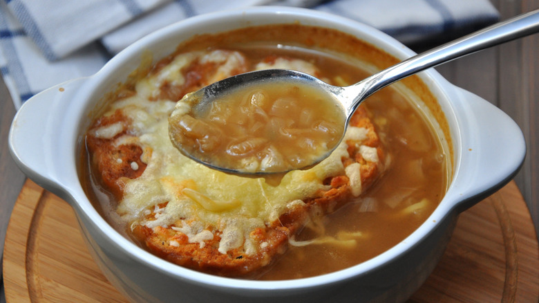 French onion soup in bowl with spoon and cheesy croute