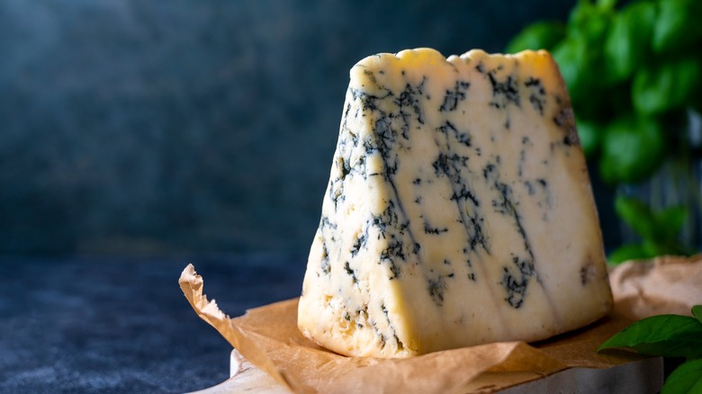 Crumbly Roquefort displayed on wooden cutting board