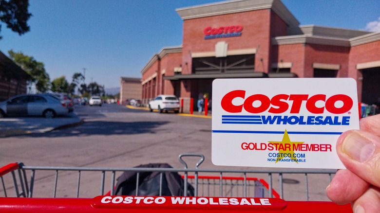 Customer holding their Costco card up to the building's entrance