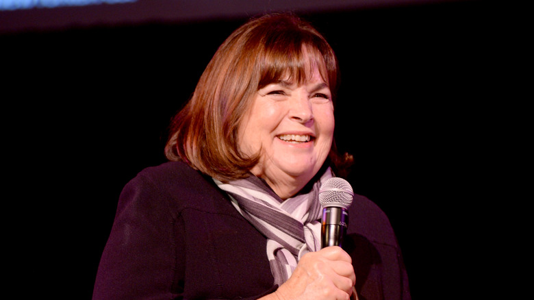 Ina Garten smiling and holding a microphone