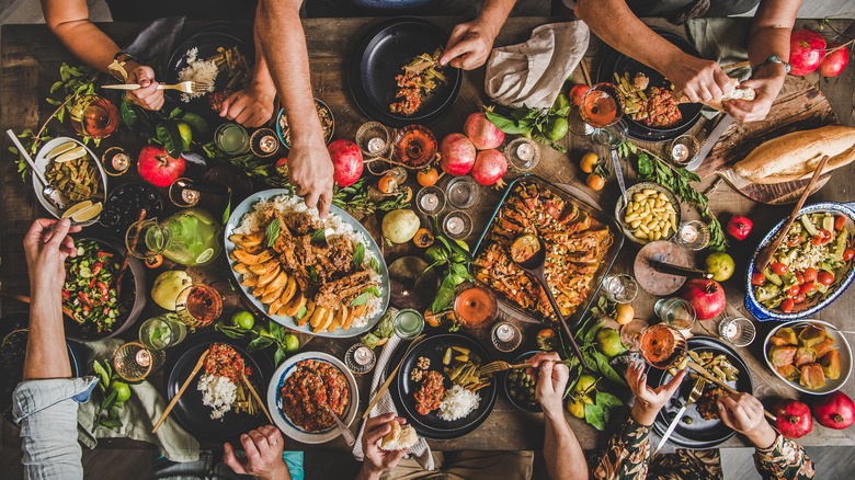 people dining at a full table of food