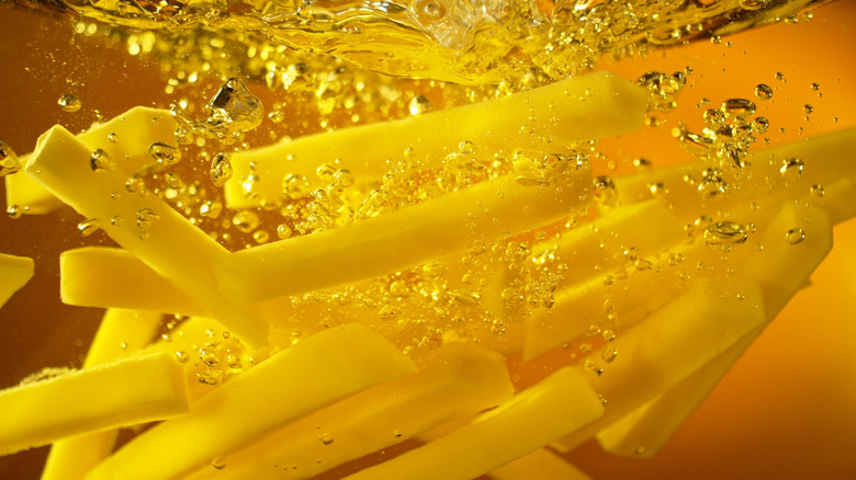 A closeup of fries in frying oil