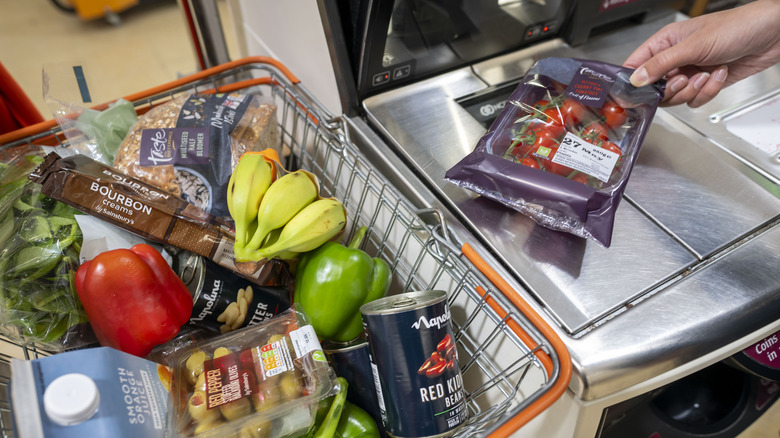 scanning basket of groceries at self checkout