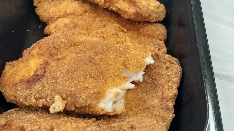 Publix-prepared fried catfish fillets sitting in a container.