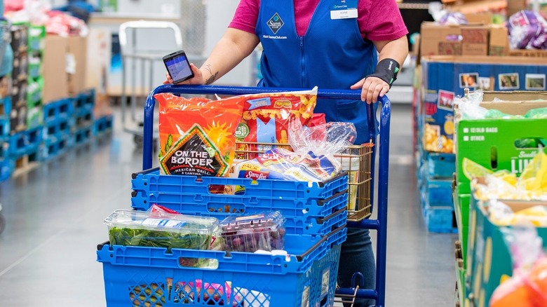 sam's club worker pushing grocery cart