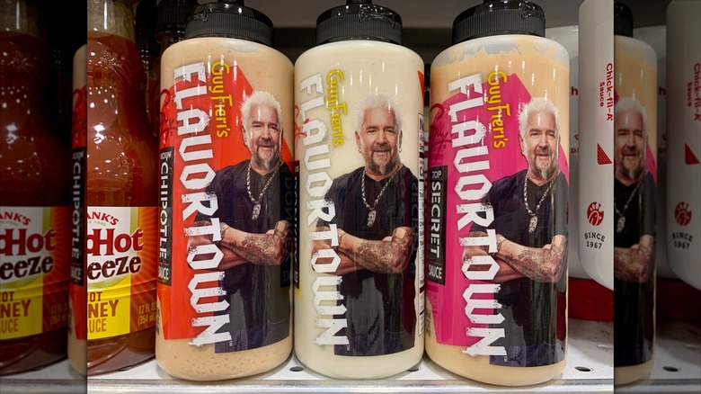 Bottles of Guy Fieri's Flavortown sauces sit on a supermarket shelf