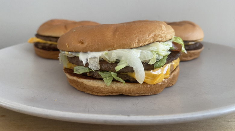 Double Quarter Pounder with Cheese served on plate with two other burgers