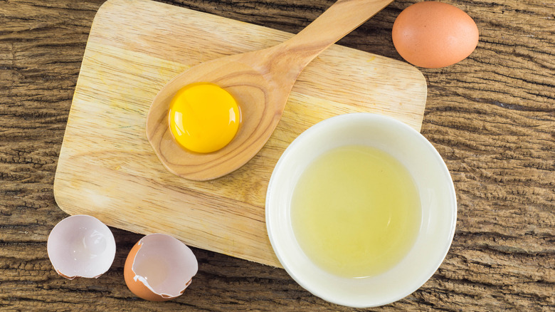 Bowls of separated egg whites and yolk in spoon