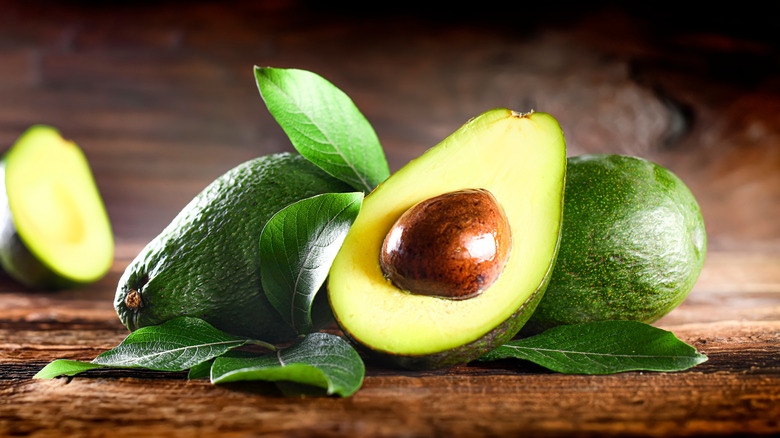 Halved avocados on wooden table