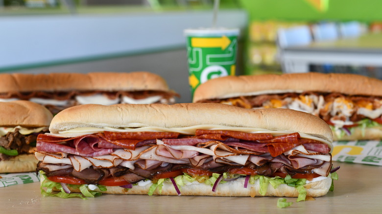 A few subway sandwiches on table