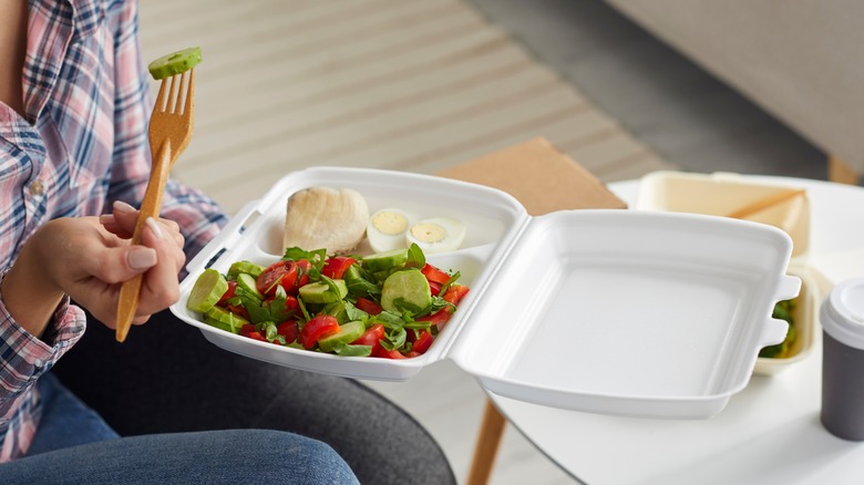 Person eating takeout salad lunch