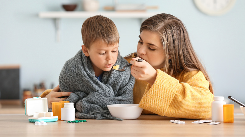 Feeding soup to sick child 