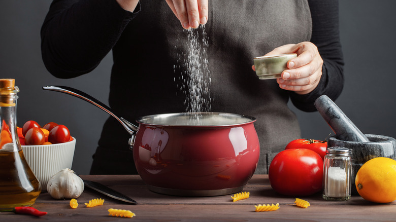 Adding salt to a pot of water