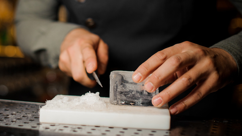 Bartender cutting ice