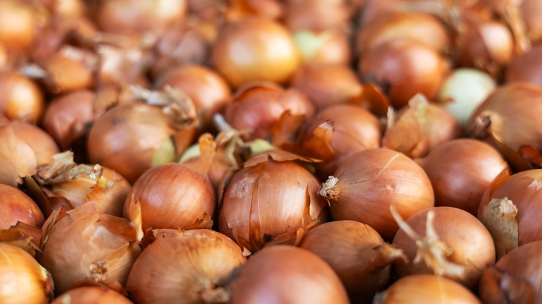 A pile of onions with the skin on