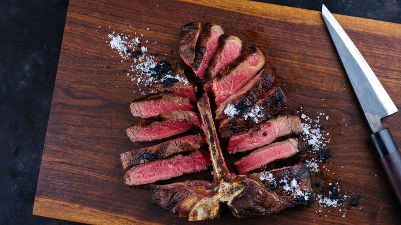 A sliced porterhouse on cutting board