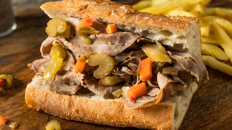 An Italian beef sandwich with celery and carrots