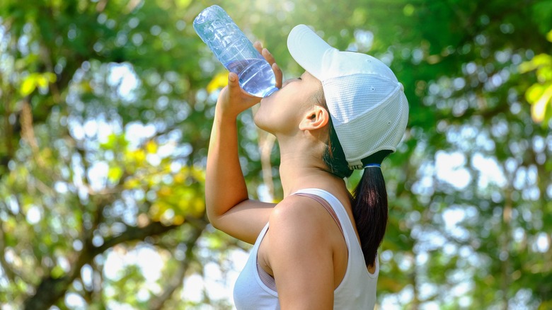 Woman athlete drinking a water bottle outside