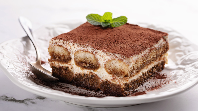 A piece of tiramisu on a white china plate