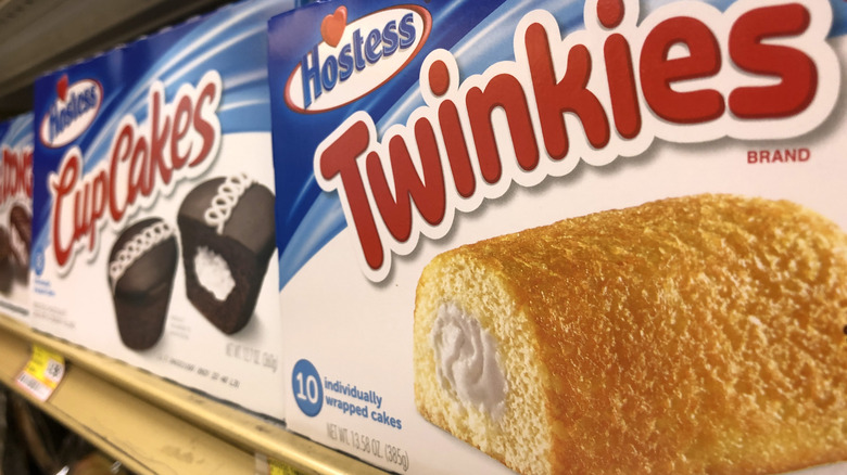 A box of Twinkies sits on a store shelf next to a box of Hostess CupCakes