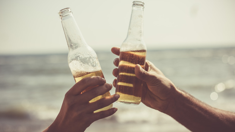 toasting beer bottles on beach