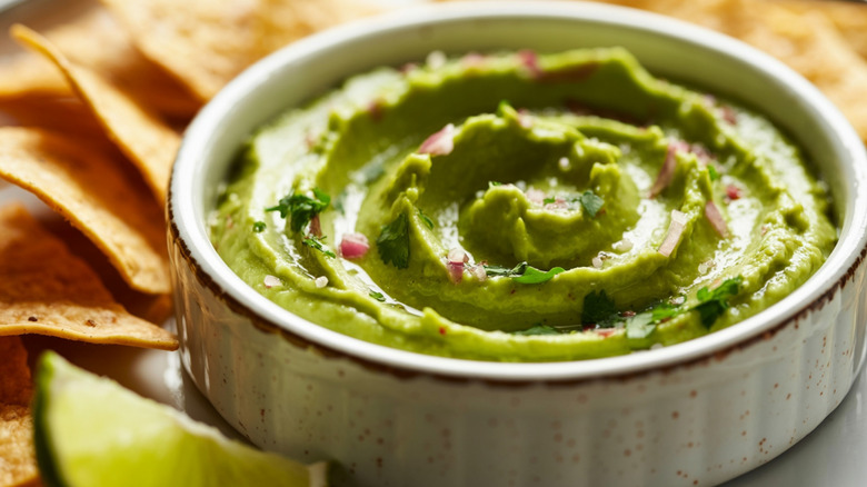 Creamy guacamole surrounded by chips