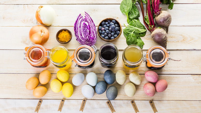 pots of dye next to fruits, veggies, and dyed eggs