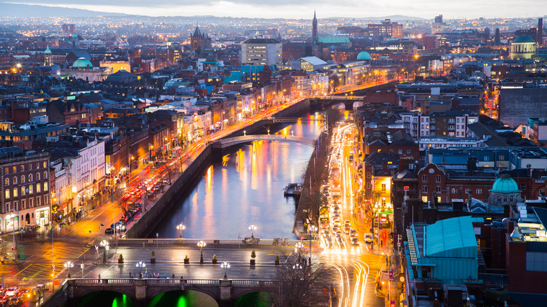 Aerial view of downtown Dublin, Ireland with lights on near a river.