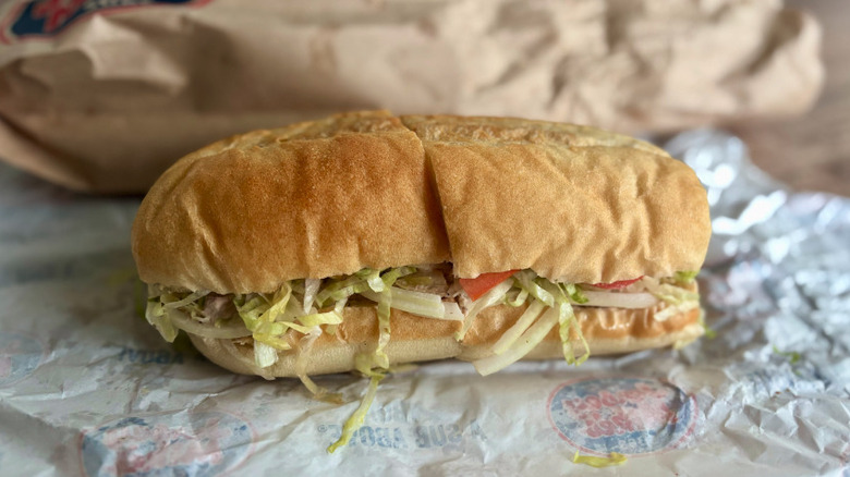 A Jersey Mike's tuna sub sitting on its wrapper