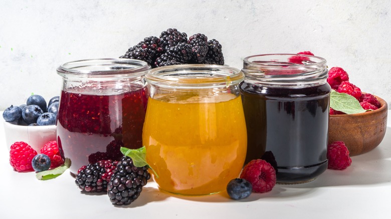 Glass jars of fruit jams with berries