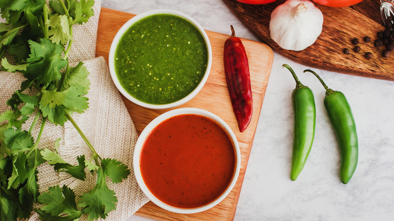 bowls of green and red hot sauce