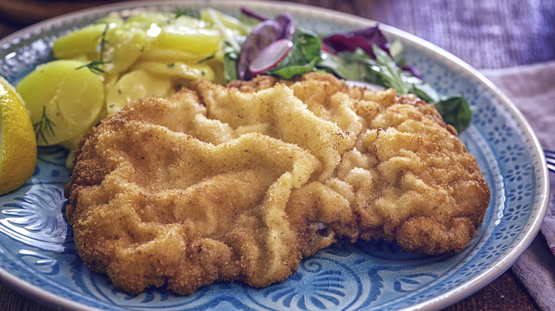 Schnitzel and potatoes on blue plate