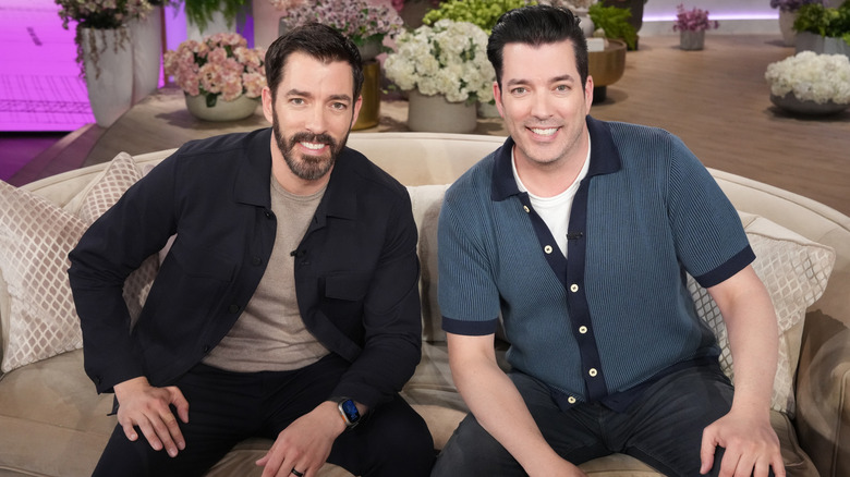 Drew and Jonathan Scott, known on television as the Property Brothers, pose together on a sofa