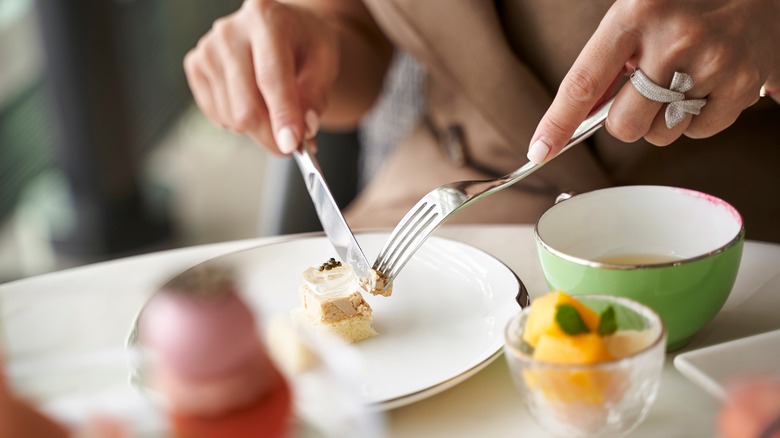 holding knife and fork at dining table