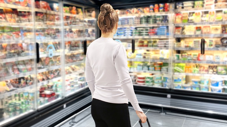 Woman in refrigerated section of grocery store