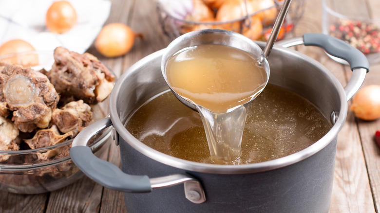 Pot of stock beside beef bones